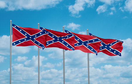 Confederate States of America battle four flags in row waving together on blue cloudy skyの写真素材