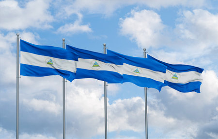 Nicaragua four flags in row waving together on blue cloudy sky, multiple flags in lineの写真素材