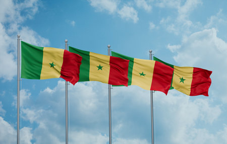 Republic of Senegal four flags in row waving together on blue cloudy sky, multiple flags in lineの写真素材