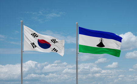 Lesotho and Brazil flags waving together in the wind on blue cloudy sky, two country relationship conceptの写真素材