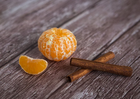 One orange and cinnamon sticks on woodenの写真素材