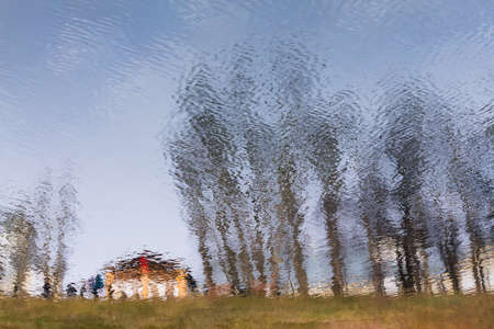 Water background with trees and blue sky reflected in the pure water. Fall, autumn season or relax concept.の写真素材