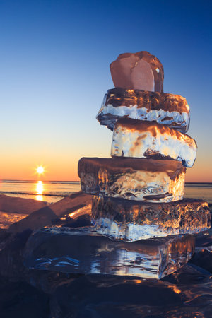 Ice blocks on surface of Baikal lake. Colorful winter sunrise.の写真素材