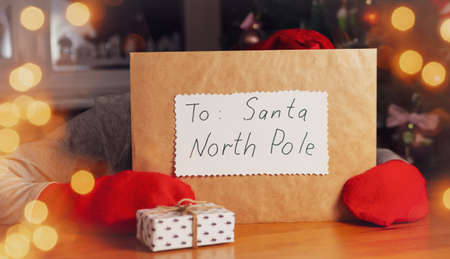 A big envelope with a letter or message to Santa North Pole. A boy keeping envelope hids behind the envelope.の写真素材