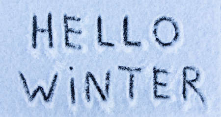 Hello Winter words written on the surface of a snow field.