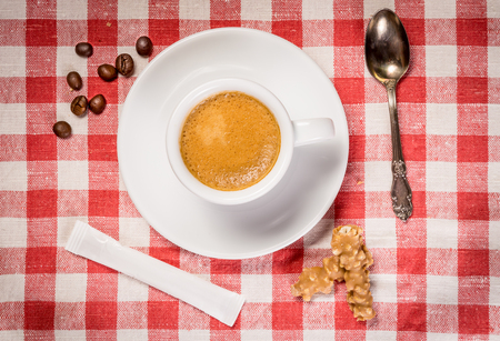Top view of white cup of coffee on a table clothの写真素材