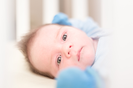 A newborn baby lying in a badの写真素材