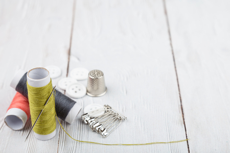 Flat lay of sewing and tailoring instruments on white wooden background with copy spaceの写真素材