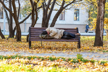 10/16/2018 Moscow, Russia: homeless man sleeping on a bench in the park in autumnのeditorial素材