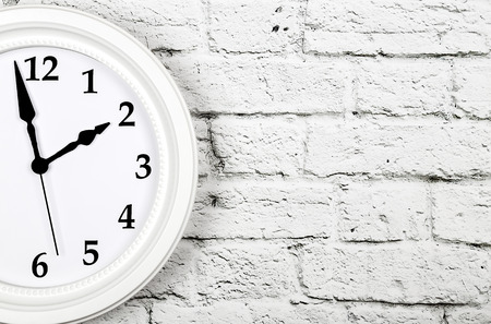 White clock on brick wall with copy space