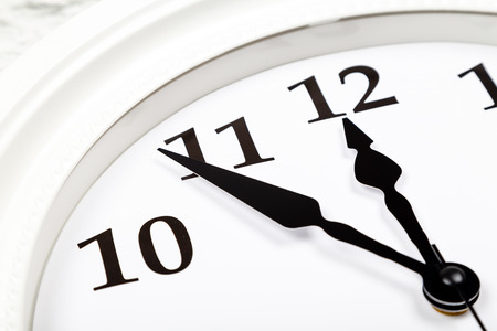 Closeup view of  black clock arrows showing the time