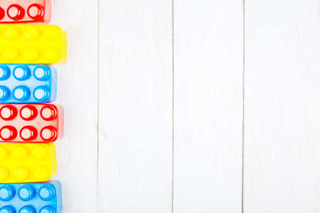 Flat lay on wooden background. Children's plastic building blocks. Mockup with copy spaceの写真素材
