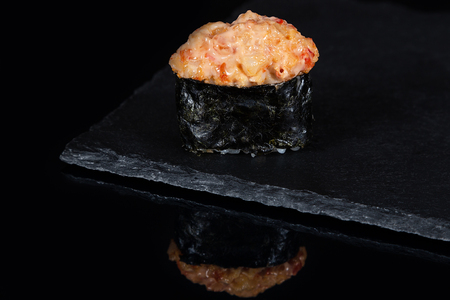 Gunkan sushi with spicy salmon on black desk with reflectionの写真素材