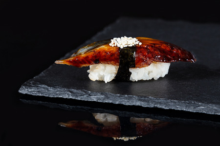 Fresh sushi with eel on black background with reflectionの写真素材