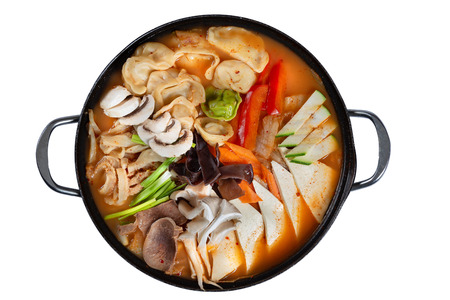 Pan of korean soup with kimchi, dumplings, beef and vegetables isolated on white backgroundの写真素材
