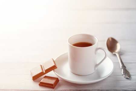 A cup of coffee with pieces of chotolate on wooden table with copy spaceの写真素材