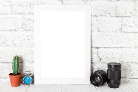White empty photo frame against brick wall. Mockup with copy space.の写真素材