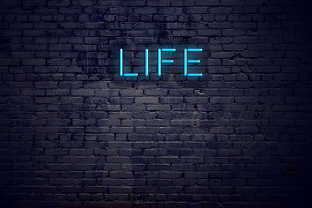 Brick wall and neon sign with text life.の写真素材