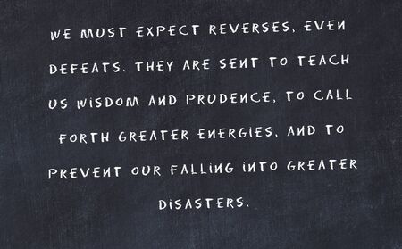 Black chalkboard with handwritten wise motivational quote .の写真素材