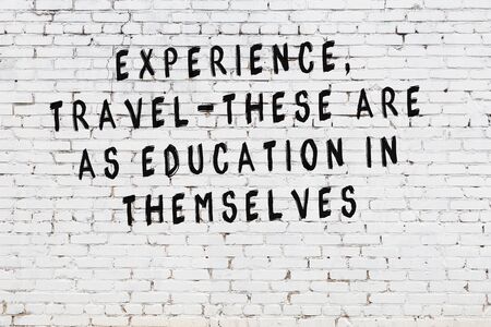White brick wall with painted black motivational quote inscription.の写真素材