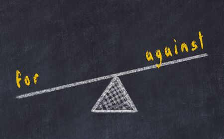 Chalk board sketch of scales. Concept of balance between for and againstの写真素材