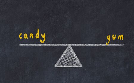 Chalk board sketch of scales. Concept of balance between candy and gum.の写真素材
