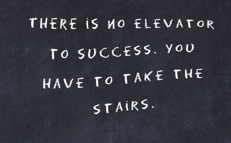 Black chalkboard with handwritten wise motivational quote .の写真素材