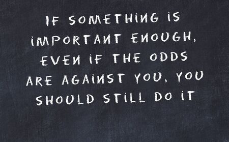 Black chalkboard with handwritten wise motivational quote .の写真素材