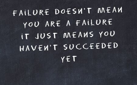 Black chalkboard with handwritten wise motivational quote .の写真素材