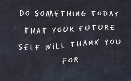 Black chalkboard with handwritten wise motivational quote .の写真素材