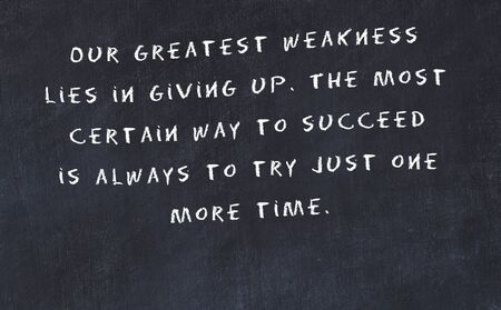 Black chalkboard with handwritten wise motivational quote .の写真素材