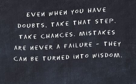 Black chalkboard with handwritten wise motivational quote .の写真素材