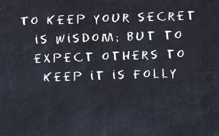 Black chalkboard with handwritten wise motivational quote .の写真素材