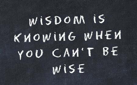 Black chalkboard with handwritten wise motivational quote .の写真素材