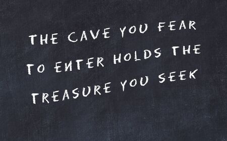 Black chalkboard with handwritten wise motivational quote .の写真素材