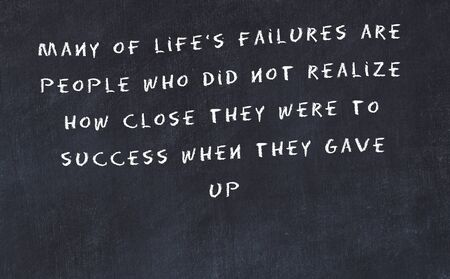 Black chalkboard with handwritten wise motivational quote .の写真素材
