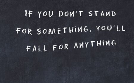 Black chalkboard with handwritten wise motivational quote .の写真素材