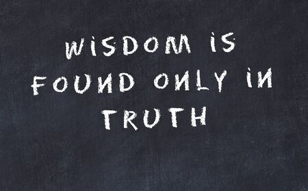 Black chalkboard with handwritten wise motivational quote .の写真素材