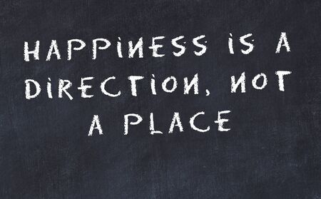 Black chalkboard with handwritten wise motivational quote .の写真素材