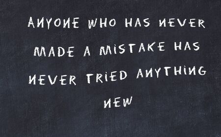 Black chalkboard with handwritten wise motivational quote .の写真素材