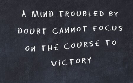 Black chalkboard with handwritten wise motivational quote .の写真素材