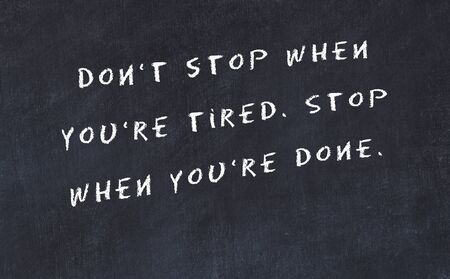 Black chalkboard with handwritten wise motivational quote .の写真素材