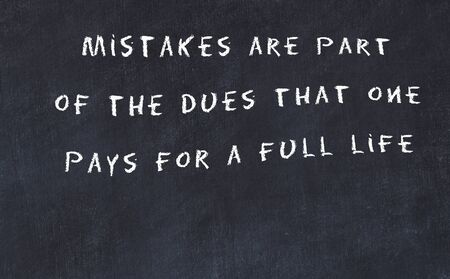 Black chalkboard with handwritten wise motivational quote .の写真素材