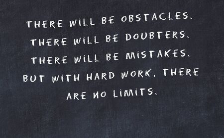 Black chalkboard with handwritten wise motivational quote .の写真素材