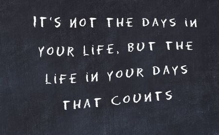 Black chalkboard with handwritten wise motivational quote .の写真素材