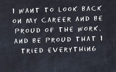 Black chalkboard with handwritten wise motivational quote .の写真素材