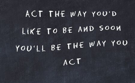 Black chalkboard with handwritten wise motivational quote .の写真素材