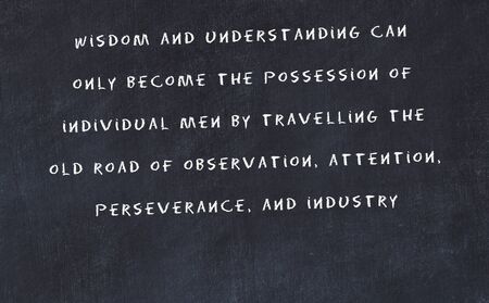 Black chalkboard with handwritten wise motivational quote .の写真素材