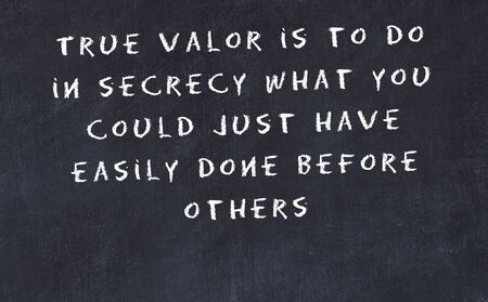 Black chalkboard with handwritten wise motivational quote .の写真素材