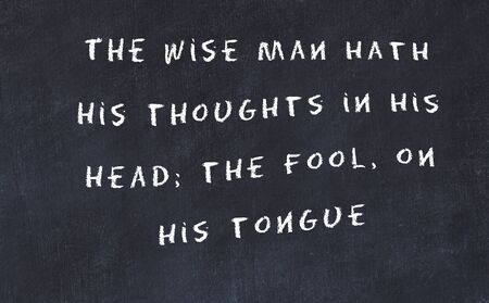 Black chalkboard with handwritten wise motivational quote .の写真素材